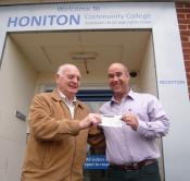 Lion Ron Webb presenting cheque for 100 to Honiton College FD Gary Wills